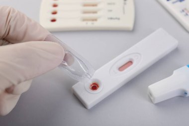 Doktor kullan-at ekspres test kasetine tampon çözeltisi bırakıyor.