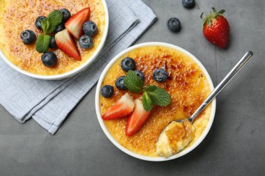 Böğürtlenli ve nane şekerli lezzetli creme brulee gri masada, düz yatıyordu.