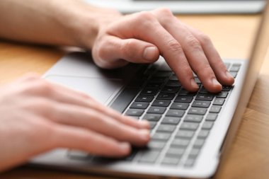 E-öğrenme. Çevrimiçi ders sırasında masadaki bilgisayarı kullanan adam, yakın plan.