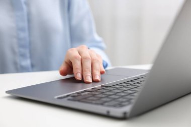 E-öğrenme. Beyaz masada dizüstü bilgisayar kullanan kadın, yakın plan.