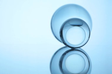 Ayna yüzeyinde şeffaf cam toplar, ışık arka planına karşı. Metin için boşluk