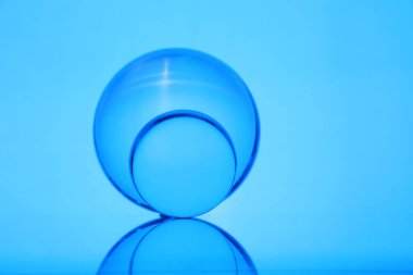 Ayna yüzeyinde şeffaf cam toplar mavi arkaplana karşı