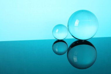 Aynanın yüzeyindeki şeffaf cam küreler turkuaz arka planda. Metin için boşluk