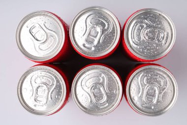 Enerji içecekleri açık gri arka planda ıslak kutularda, üst görünümde.