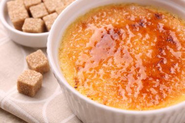 Lezzetli creme brulee kasede ve şeker küpleri masada, yakın plan
