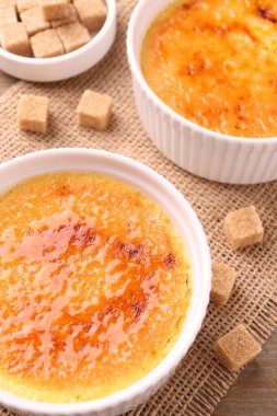 Tabaklarda nefis creme brulee ve şeker küpleri masanın üstünde, yukarıda.