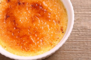 Tahta masadaki kasede nefis krem brulee, üst manzara.