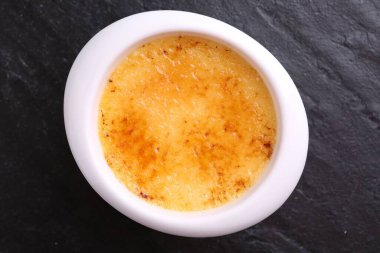 Koyu gri desenli masada, kasede nefis krema brulee, üst manzara.