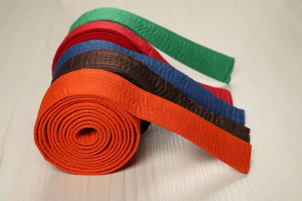 stock image Colorful karate belts on wooden background, closeup