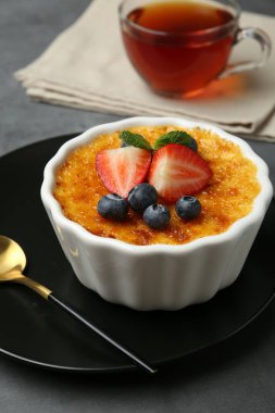 Böğürtlenli nefis creme brulee ve gri masadaki nane şekeri, yakın plan