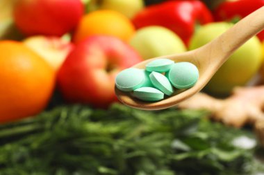 Ürünlerin yanındaki ahşap kaşıkta diyet takviyeleri, yakın çekim. Metin için boşluk