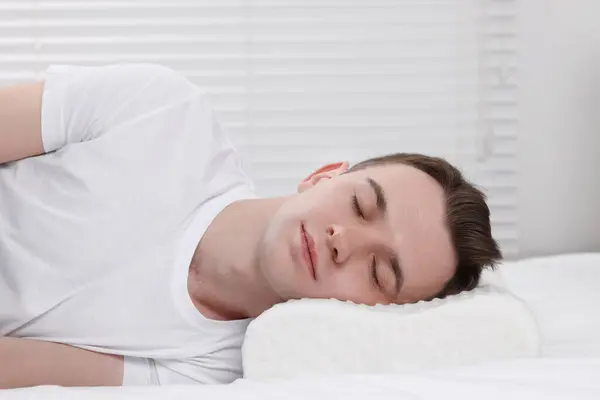 Man sleeping on orthopedic pillow at home