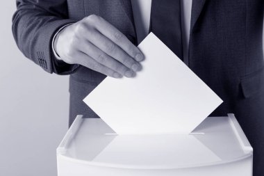 Adam oyunu arka plandaki sandığa koyuyor, yakın plan. Renk tonlu