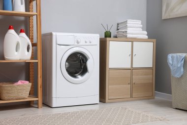 Çamaşır makinesi ve mobilyalarla iç çamaşır odası.