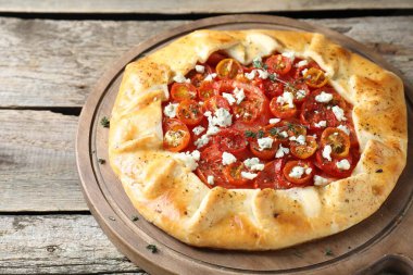 Ahşap masa üzerinde domates, kekik ve peynirli lezzetli galet (Caprese galette), yakın çekim
