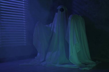 Ürkütücü hayalet. Pencerenin yanında, mavi ışıkla kaplanmış kadın.