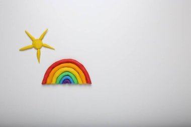 Beyaz arka planda plastikten yapılmış gökkuşağı ve güneş, üst görünüm