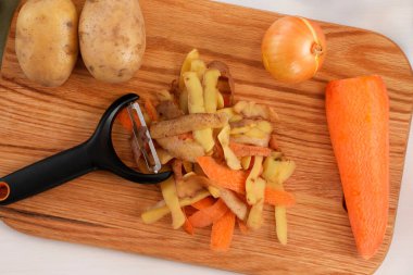 Taze sebze kabukları ve soyucu beyaz masa, üst manzara