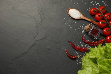 Yemek pişirme konsepti. Kaşık ve farklı ürünler siyah masada, düz yerde. Metin için boşluk