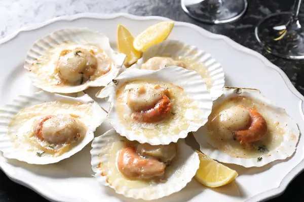 Fried scallops in shells on table, closeup