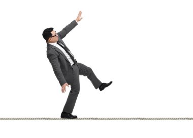 İş sahibi olmanın riskleri ve zorlukları. İpte beyaz arkaplan ile dengelenen adam