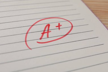 Okul derecesi. Not defteri kağıdında artı işareti olan kırmızı harf A, kapat