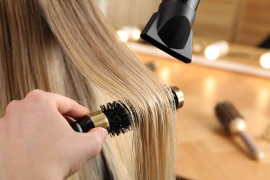 Kuaför kuaför kuaförde müşterinin saçını kurutuyor.