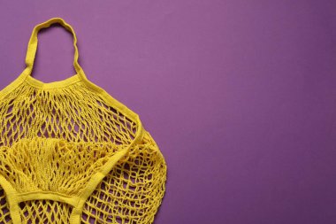 Mor arka planda sarı ağ torbası, üst manzara. Metin için boşluk