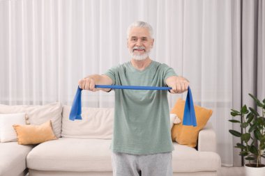 Son sınıf öğrencisi evde spor yapıyor. Lastik bantla.