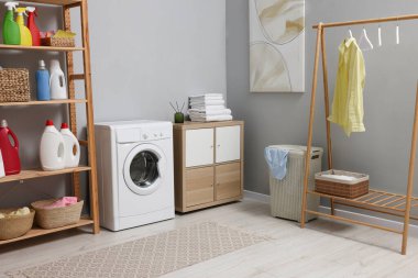 Çamaşır makinesi ve mobilyalarla iç çamaşır odası.