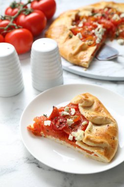 Beyaz mermer masa üzerinde domates ve peynirli (Caprese galette) leziz galette, yakın çekim