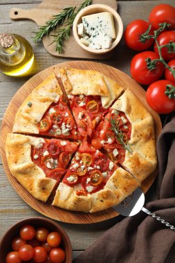 Tahta masa üzerinde domates, biberiye ve peynir (Caprese galette) ile lezzetli galet düz bileşimi yatıyordu