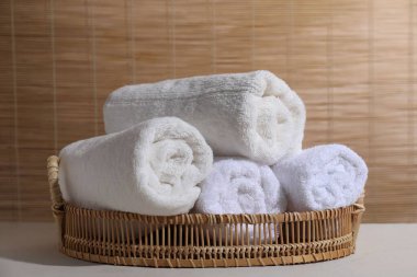 Beyaz masa içinde yuvarlanmış havlular.