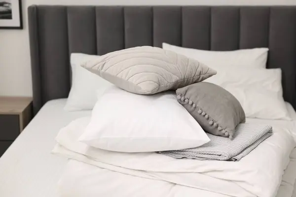 Soft pillows and bedding set on bed at home