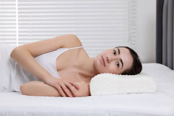 Woman lying on orthopedic pillow at home