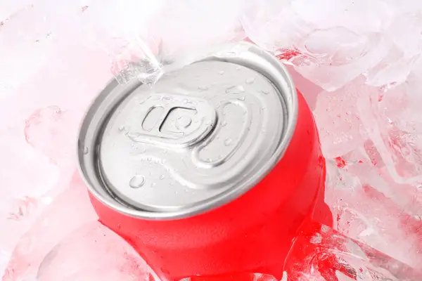 Energy drink in wet can and ice cubes, closeup