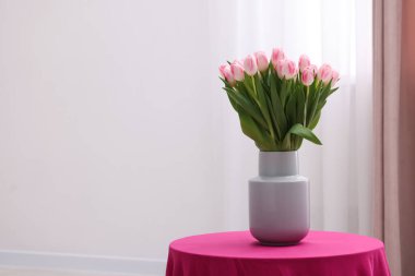İçerideki masada taze pembe lalelerden oluşan güzel bir buket. Metin için boşluk