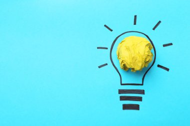 Fikir konsepti. Kırışık kağıttan yapılmış ampul ve açık mavi arkaplan üzerine çizim, üst manzara. Metin için boşluk