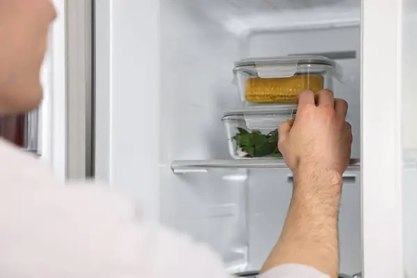 Man taking containers with vegetables out of refrigerator, closeup