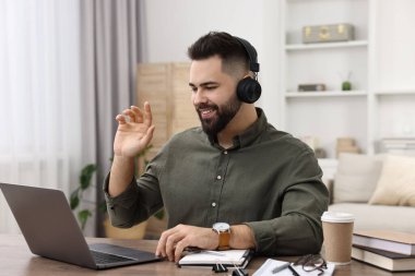 E-öğrenme. Genç adam çevrimiçi ders sırasında bilgisayar kullanıyor.