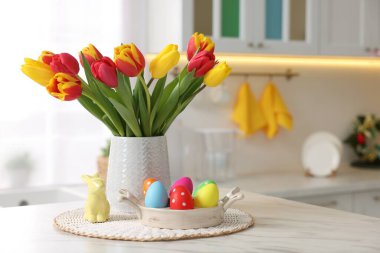 Paskalya süsleri. Bir buket lale, boyanmış yumurtalar ve içeride masanın üzerinde tavşan figürü. Metin için boşluk
