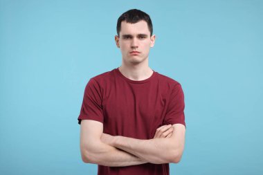 Açık mavi arka planda üzgün bir adamın portresi