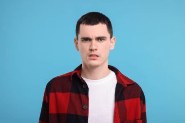 Açık mavi arka planda şaşırmış bir adamın portresi