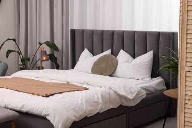 Büyük yatak odası, lamba ve çiçek desenli.