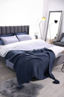 Şık bir yatak odasında, yatakta parlak ekose. İç tasarım