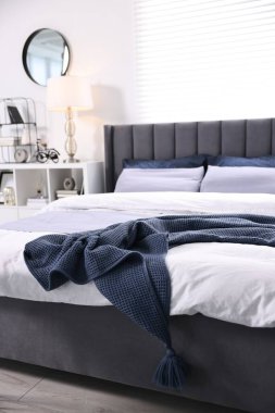 Şık bir yatak odasında, yatakta parlak ekose. İç tasarım