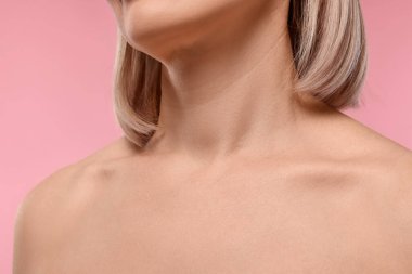 Pembe arka planda sağlıklı cildi olan kadın, yakın plan.