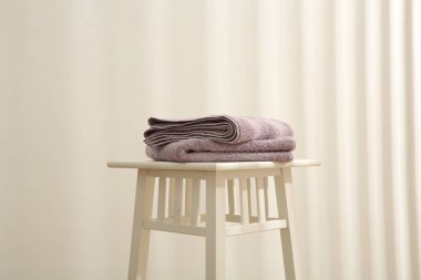 Beyaz duvara karşı menekşe havlular.