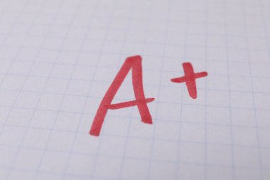 Okul derecesi. Not defteri kağıdında artı işareti olan kırmızı harf A, kapat