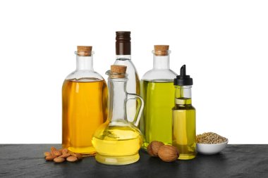 Sebze yağları. Ahşap masadaki farklı yağlar ve malzemeler beyaz arka plana karşıdır.